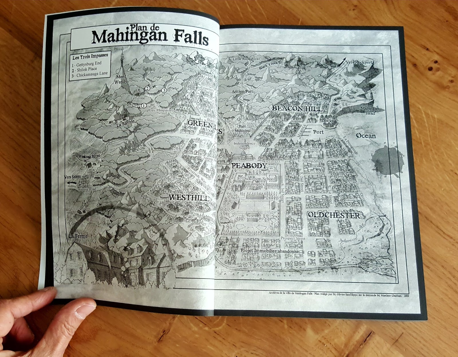 Le roman Le Signal ouvert sur la page du plan de la ville de Mahingan Falls.